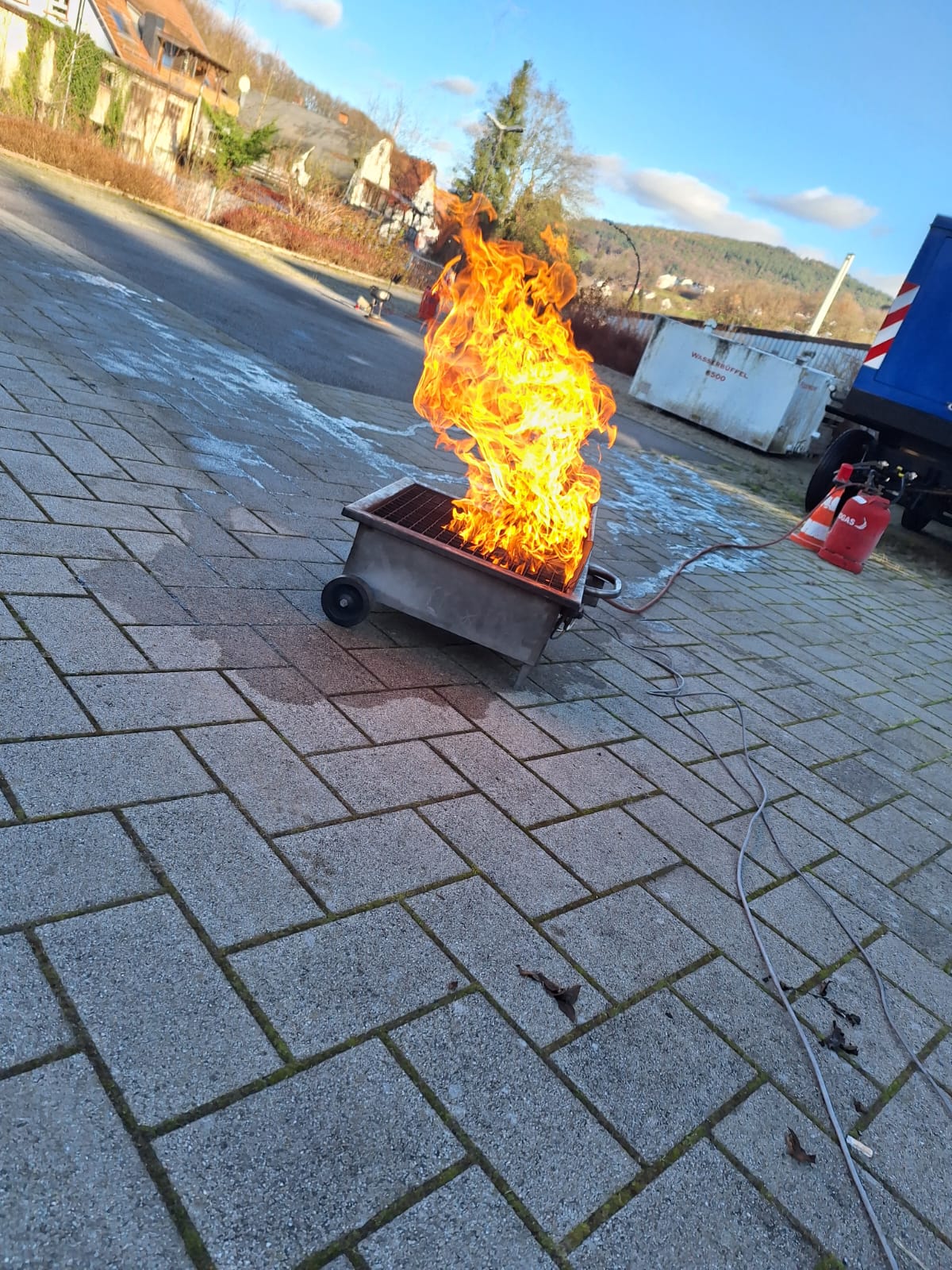 Praktische Löschübung mit einem Feuerlöscher an einem Übungsfeuer